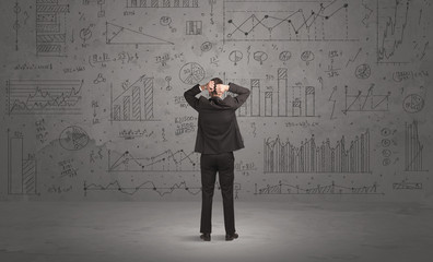 Salesman with business charts on wall
