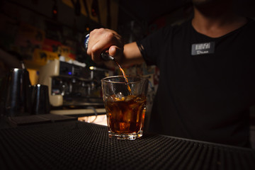 Bartender pouring alcohol into a glass