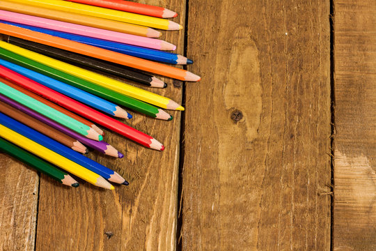 close up picture of colorful pencils on old wooden table