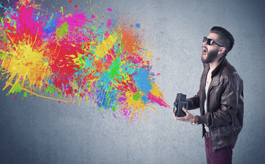 Hipster guy with camera and paint splash