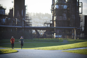 Two adult women running through Gasworks Park in Seattle, Washington.