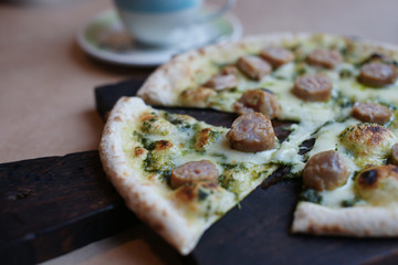 Pizza with sausage on the table in the restaurant.