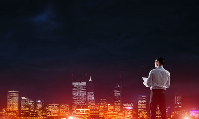 Businessman viewing night glowing city