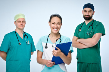 A team of three young doctors. The team included a doctor and a woman, two men doctors. They are dressed in scrubs.