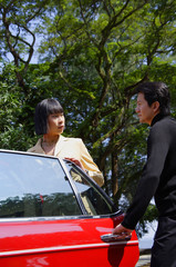 Man holding car door open for woman