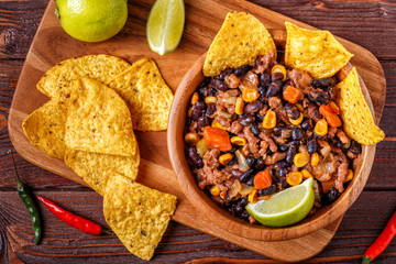 Chili con carne in bowl with tortilla chips.