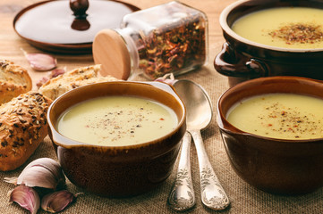 Garlic cream soup with cheese on brown wooden background.