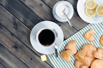 Foods of the Italian breakfast with tea and biscuits on an old wooden table, photographed from above