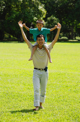Obraz premium Father carrying son on shoulders