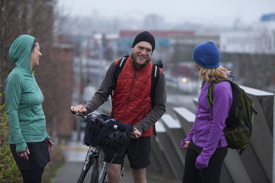 A man with a bike and two women chatting on a Seattle, Washington bike path.
