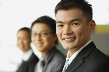 Business people seating in a row, focus on the businessman in foreground