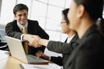Business people shaking hands across table