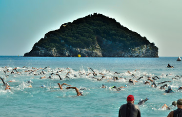 Athletes swim in the sea during a swim the island