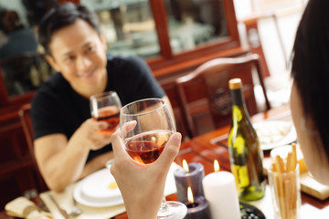 Couple holding wine glasses, sitting opposite each other