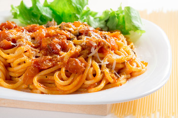 Spaghetti with bolognese and parmesan on a white plate