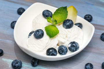 Vanilla ice cream with mint and blueberry  in white plate
