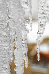 Bright icicles which are hanging down from a roof. Old town city