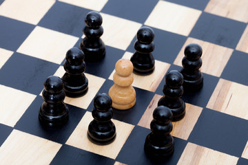 White pawn surrounded by  black ones