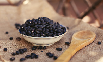 Fototapeta na wymiar Organic black beans natural protein with wooden spoon