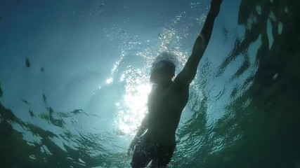 UNDERWATER: Athletic young man swimming crawl on freestyle swimming competition - Powered by Adobe
