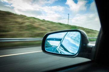 car on the road and rear view mirror