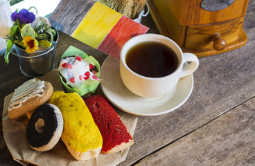 Belgium patriotic breakfast - King's Feast. cookies with red black and yellow glaze as the Belgian flag colors. cup of coffee and a homemade flag of Belgium