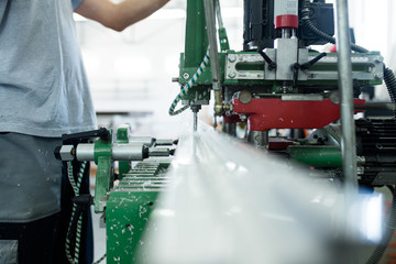 Fototapeta premium Factory for aluminum and PVC windows and doors production. Manual worker assembling PVC doors and windows. 