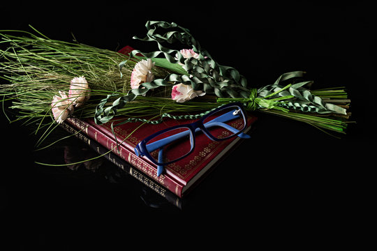 Libro, gafas y flores rosas.