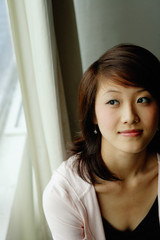 Woman sitting by window, looking away