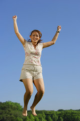 Woman jumping in mid air, smiling at camera