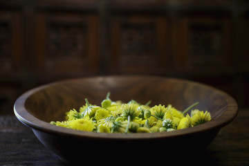 Yellow chrysanthemum flowers in wooden bowl