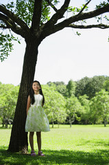 Fototapeta na wymiar Girl in park, standing under tree