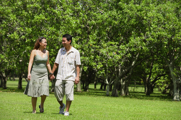 Obraz premium Couple walking in park, holding hands
