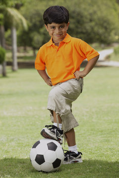 little boy with foot on soccer ball