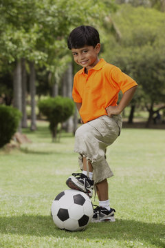 little boy with foot on soccer ball