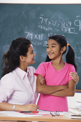 teacher with arm around student, both looking at each other