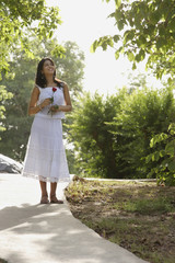 teen girl walking on path through park, with rose