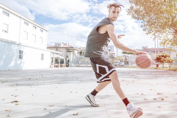 basketball player action on open court playing with the ball on a bright sunny day