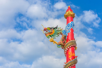 Golden dragon statue on pole, Thailand, Dragon prominently in the beautiful on blue sky background