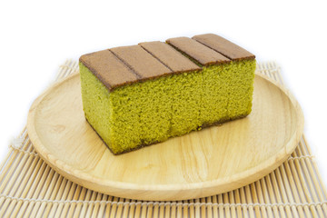 Japanese Matcha green tea cake cheesecake on wooden plate and traditional mat isolated white background