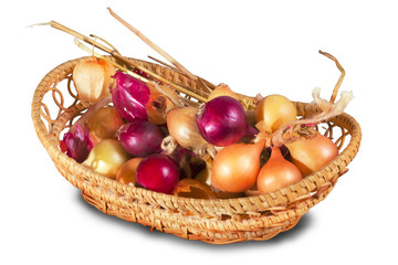 Bunch of beige and purple onions in wicker basket