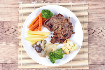 Home made ,Pork steak and mixed vegetables served.