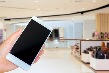 hand holding the white smartphone on blurred background