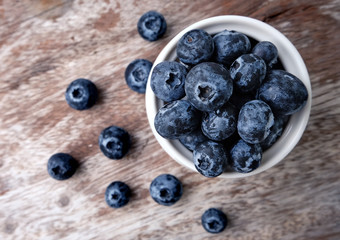 bowl of blueberries on wooden background