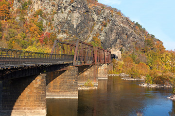 Fototapeta na wymiar Bridge on the Appalachian Trail where the Potomac River meets the Shenandoah River. Autumn landscape in Harpers Ferry, West Virginia, USA.