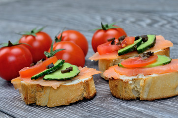 bruschetta with salmon and tomato on table