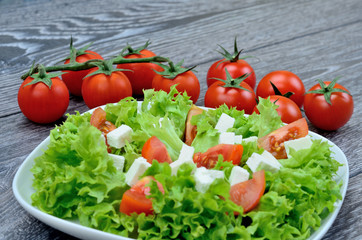 salad in dish and tomato on table