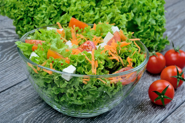 salad in bowl and tomatos on table
