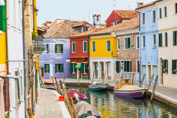 Fototapeta na wymiar Small canal lined with colorful houses on the island of Burano (Venice, Italy). All potential trademarks are removed.