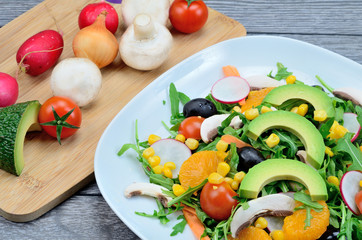 salad with mandarin and avocado in dish on table
